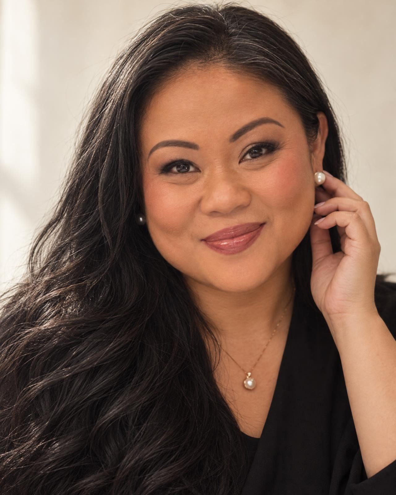 Linh Tran touching her pearl earring